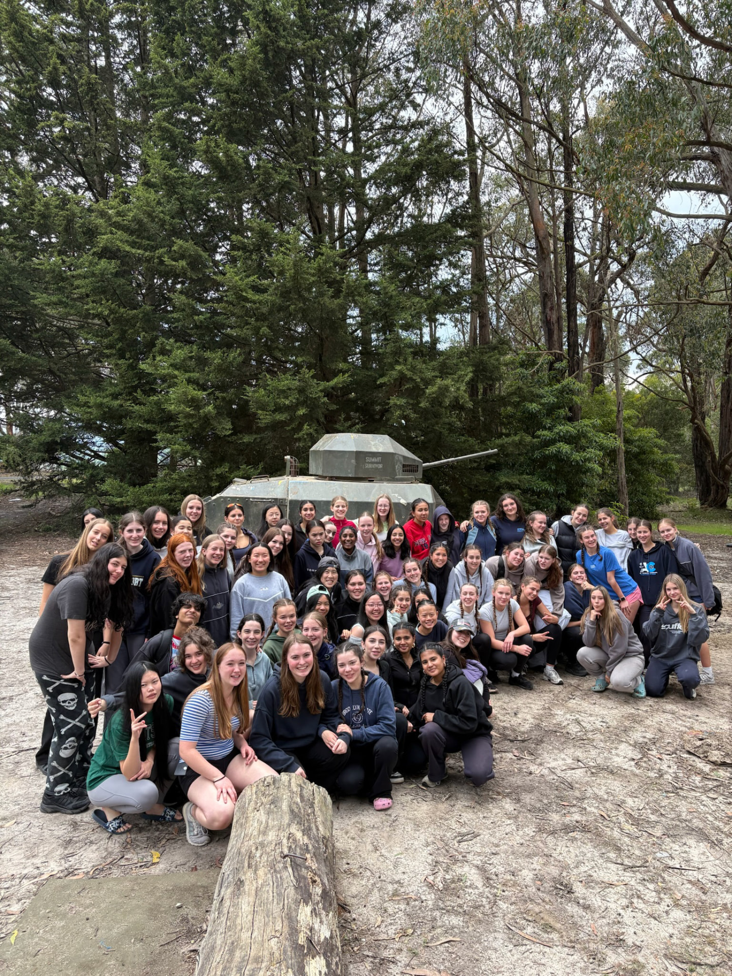 Year 9 students posing in front of the Summit Survivor tank at The Summit, Gippsland